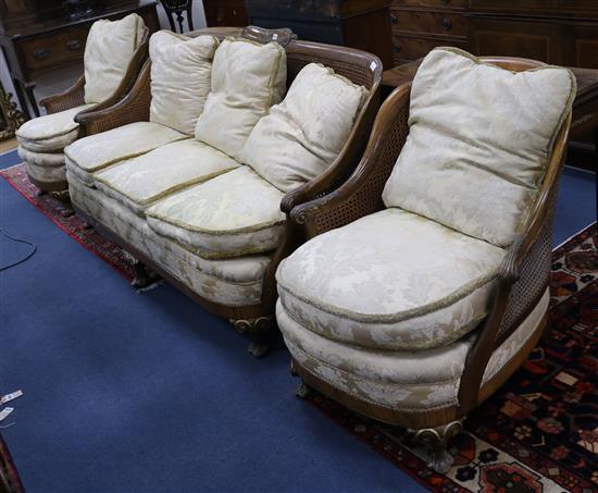 A 1930s three piece parcel gilt walnut double caned bergere suite settee W.190cm